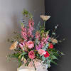 This beautiful flower arrangement of fresh mixed seasonal blooms is made by