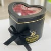 Heart-shaped black gift box with red roses and a ribbon bow