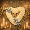 A graceful open heart easel crafted with soft white blossoms and serene
