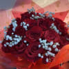 Bouquet of red roses with light blue baby's breath in pink wrapping