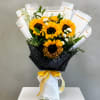 Bouquet of sunflowers wrapped in white and black paper with a yellow ribbon