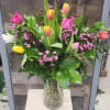 Mixed tulip bouquet with pink and yellow blooms in a glass vase