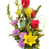 Tall mixed arrangement of red roses, yellow lilies, and purple carnations in a white pot