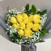 Bouquet of yellow roses with white baby's breath in gray wrapping