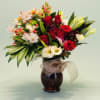 A lush, rounded bouquet of red roses and white lilies anchored by