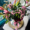 Soft pink lilies unfurl above a cloud of petite pink dianthus and