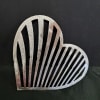 A hand-crafted metal heart wall hanger brings a graphic, romantic touch to