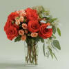 A bold cluster of vivid red roses softened by peach spray roses