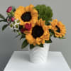 Three  or so bold golden sunflowers take center stage in this