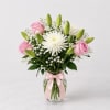 A soft and elegant vase arrangement featuring delicate pink roses, fresh white