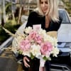 Soft pink and ivory roses form a romantic hand-tied bouquet or black