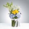 Blue hydrangeas and bright yellow roses come together in a spirited, polished