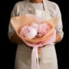 Pink peonies and pompom flowers wrapped in pastel paper
