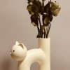 Sunshine-yellow roses tucked into a cream ceramic cat-shaped vase make this flower