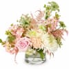 Soft pink roses and pale peach carnations mingle with white chrysanthemums and