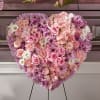 Heart-shaped floral arrangement of pink, lavender, and white blooms on an easel