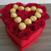 Heart-shaped box of red roses topped with gold-wrapped chocolates
