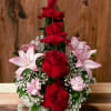 Red roses with pink lilies and carnations in a tiered arrangement