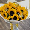 Bouquet of yellow sunflowers wrapped in white paper with gold trim