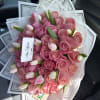 Bouquet of pink roses and tulip buds wrapped in clear paper