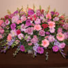 A sweet display to this casket arrangement in lovely pinks and purples.