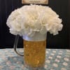 A rounded cloud of white carnations sits cheerfully in a clear beer