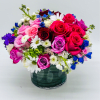 A vibrant, round floral arrangement featuring a mix of pink, red, and