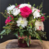 Hot pink roses, spray roses, and white daisies in a pink vase