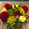Low bouquet of red and yellow flowers in a container