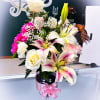 Mixed bouquet with white lilies, roses, and pink carnations in a vase