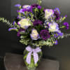 White roses edged in lavender meet deep purple carnations in this cheerful