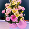 Pink and yellow floral arrangement in a pink Tiffany & Co. box with balloons