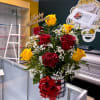Bouquet of red and yellow roses in a glass vase with a red bow