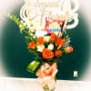 This vase array of orange and ivory roses will put a smile
