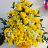 An autumn‑inspired arrangement in a pumpkin base, featuring all‑yellow blooms including yellow