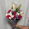 Vivid pink roses paired with creamy white lilies and small purple aster-like