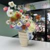 Pink dahlias, pale blue hydrangea, white daisy-like blooms and bright orange pincushions