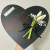 Heart-shaped black memorial box with white tulips and baby's breath