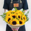 Bouquet of bright yellow sunflowers wrapped in white paper