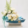 A charming baby boy gift arrangement designed in a decorative blue boat