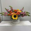 A bold sunflower takes center stage in this cheerful mixed-color flower arrangement