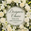 A circular white wreath with layered cream and white blooms and soft