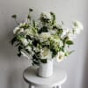 White flower arrangement in a ribbed white vase