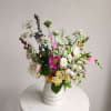 Mixed bouquet in a white ceramic vase with pink, white, and purple flowers
