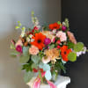 This beautiful flower arrangement of fresh mixed seasonal blooms is made by