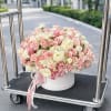 A lush dome of blush pink and ivory roses with soft peach