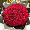 Round bouquet of red roses wrapped in black paper