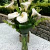 White calla lilies arranged in a clear glass vase