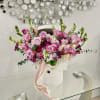 A lush cluster of pink and lavender roses crowned with pale hydrangea