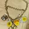 Bright, nostalgic daisies pressed in clear resin give this charm necklace a